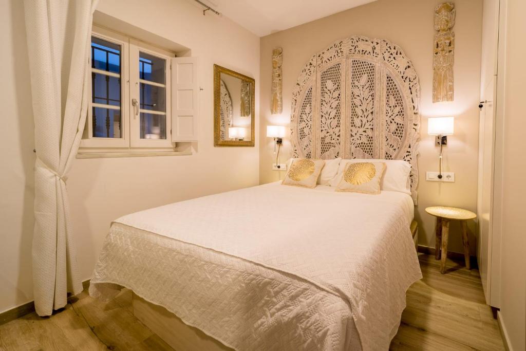 een slaapkamer met een wit bed en een raam bij Suite Capitán 1 in Cádiz