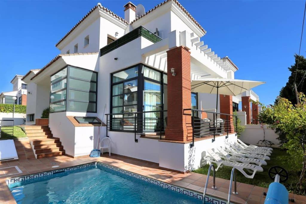 una casa con piscina frente a ella en 011 Bright and Spacious Villa with Private Pool, en Benalmádena