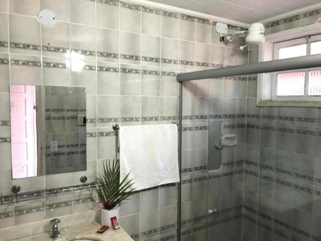 une salle de bain avec une douche avec un lavabo et un miroir dans l'établissement Villa Solarium Pousada, à Cabo Frio