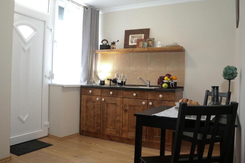 a kitchen with a sink and a table and a window at Pálma Apartmanok Szálláshely Százhalombatta 5a in Százhalombatta