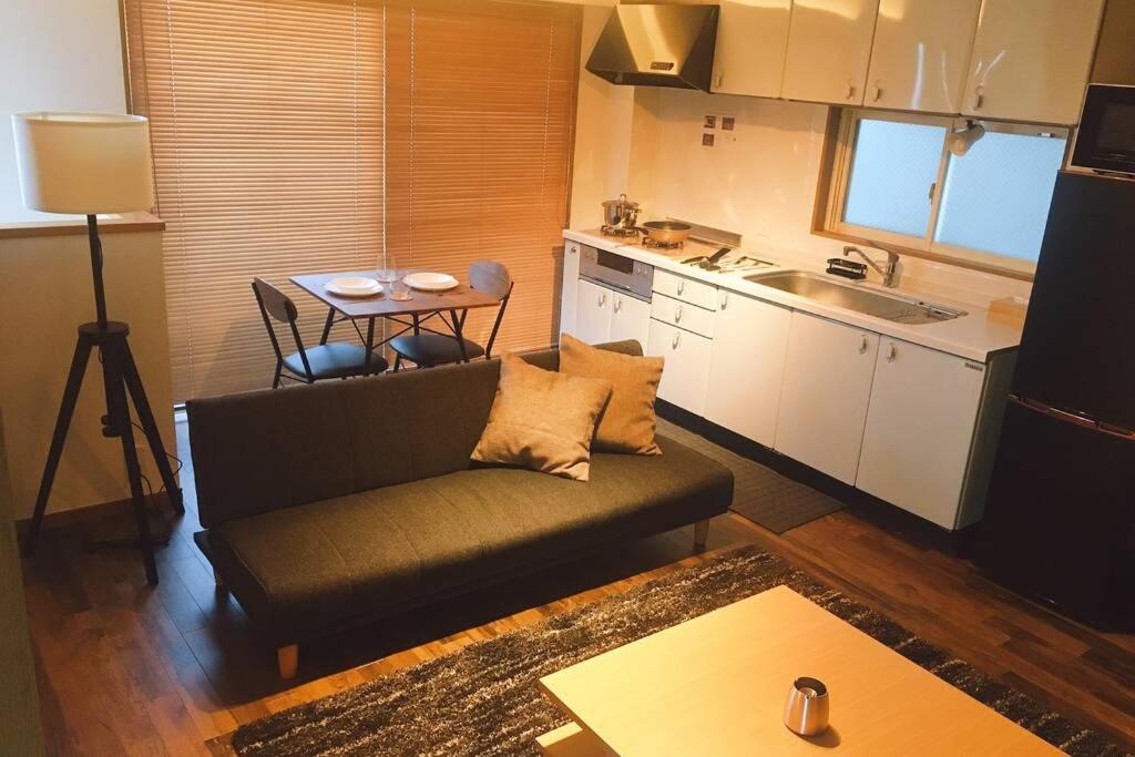 sala de estar con sofá y cocina en Chill Inn Honan, en Tokio