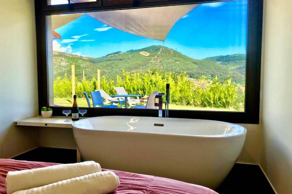 uma banheira num quarto com uma grande janela em Casa Nueva de Vigo con Jacuzzi y chimenea em Mos