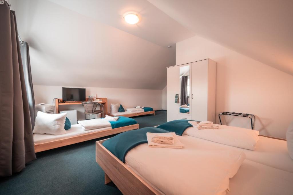 a attic bedroom with two beds and a mirror at Airport Lounge Hotel Düsseldorf in Düsseldorf