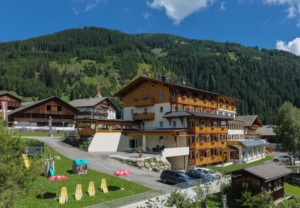 un hotel en un pueblo con una montaña en Hotel-Gasthof Andreas, en Obertilliach