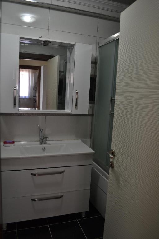 y baño con lavabo y espejo. en Almasa Suite Aparts, en Termal