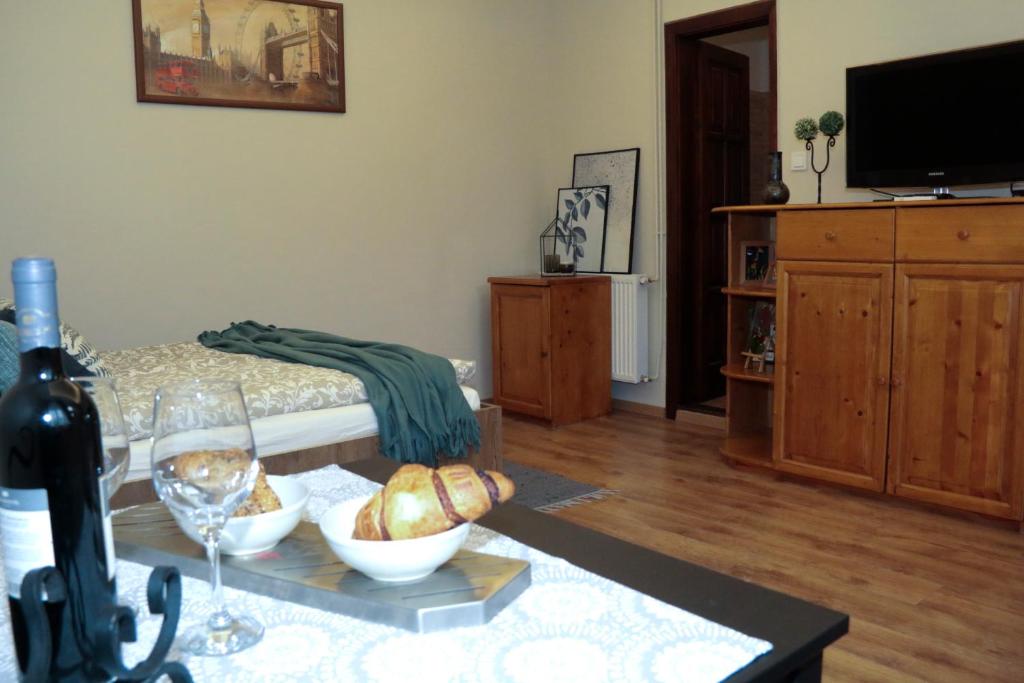 Sala de estar con mesa y botella de vino en Pálma Apartmanok szálláshely Százhalombatta 6a, en Százhalombatta