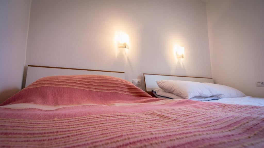 a bedroom with two beds and two lights on the wall at Holiday Home Dubi in Kornić
