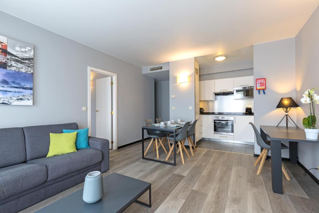 - un salon avec un canapé et une table dans l'établissement Thon Hotel Residence Parnasse Aparthotel, à Bruxelles
