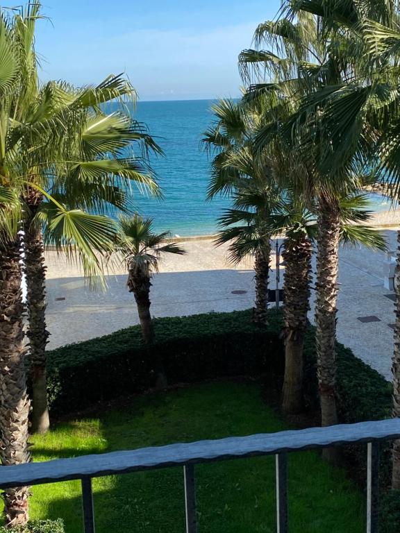 widok na plażę z palmami i ocean w obiekcie Appartamentino Celeste w mieście Porto Recanati