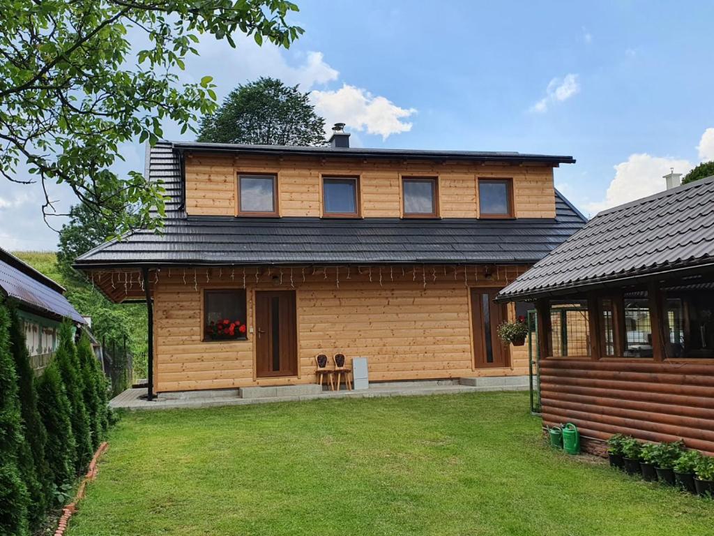 una casa de madera con dos perros sentados frente a ella en Apartmány Švec, en Terchová
