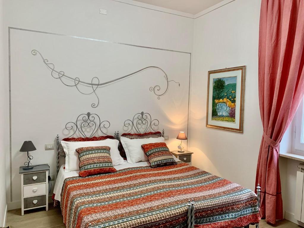 a bedroom with a large bed with red curtains at Atmosfera d'Arte - Private parking in Orvieto