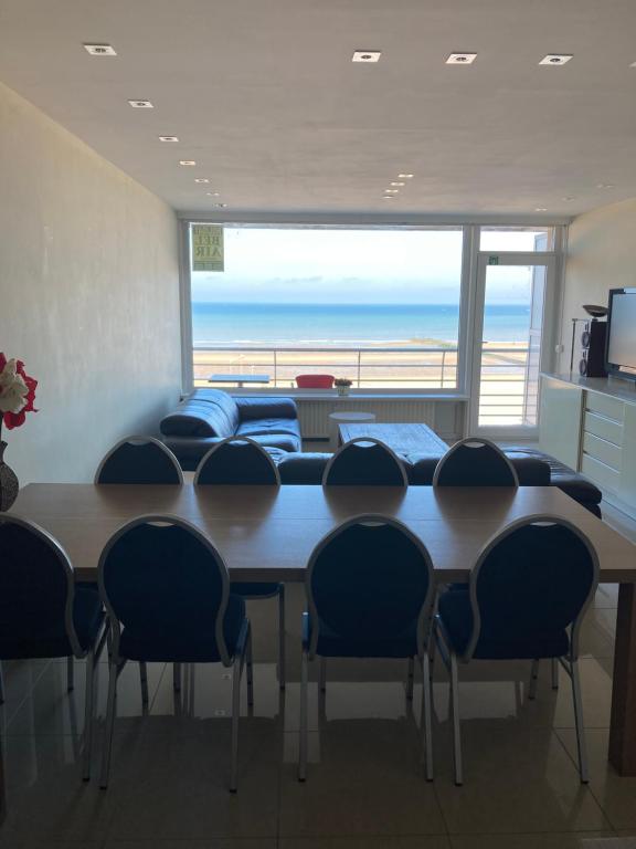 einen Konferenzraum mit einem Tisch, Stühlen und Meerblick in der Unterkunft "Hasselt" - Amazing Seaview apartment in Ostende