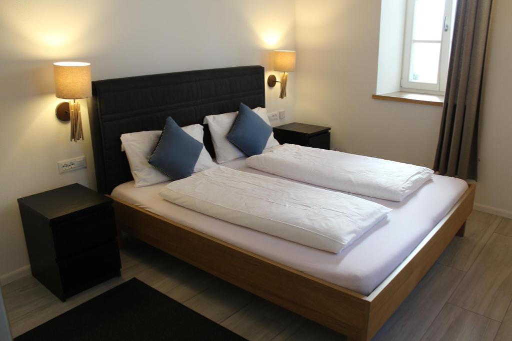 a bedroom with a large bed with white and blue pillows at Apartments Rathaus 008 - Municipio 008 in Bolzano