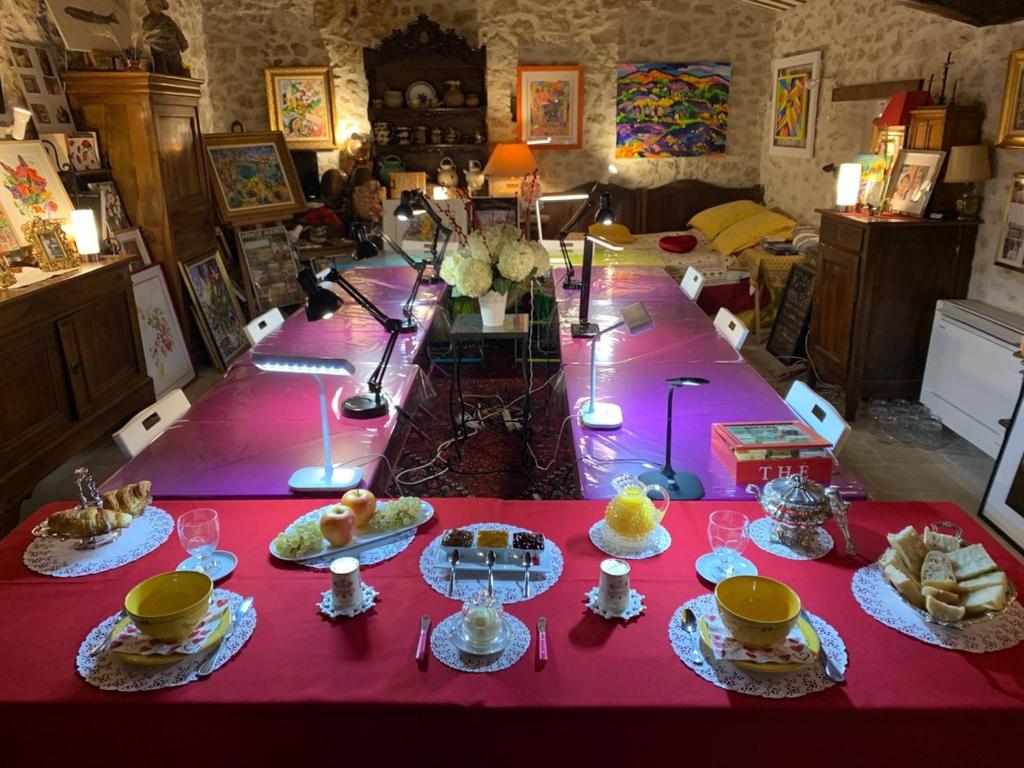 una mesa con platos de comida en un mantel rojo en La Maison du Peintre en Provence, en Mallemort