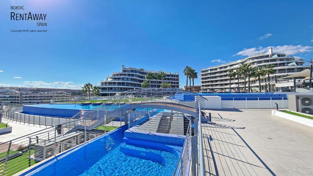 eine Brücke über einen Pool mit einer Wasserrutsche in der Unterkunft Infinity View Penthouses by NRAS in Arenales del Sol