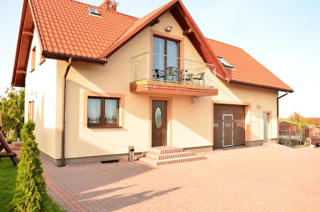dom z balkonem na podjeździe z cegły w obiekcie Pokoje gościnne u Grażki w mieście Jerzmanowice