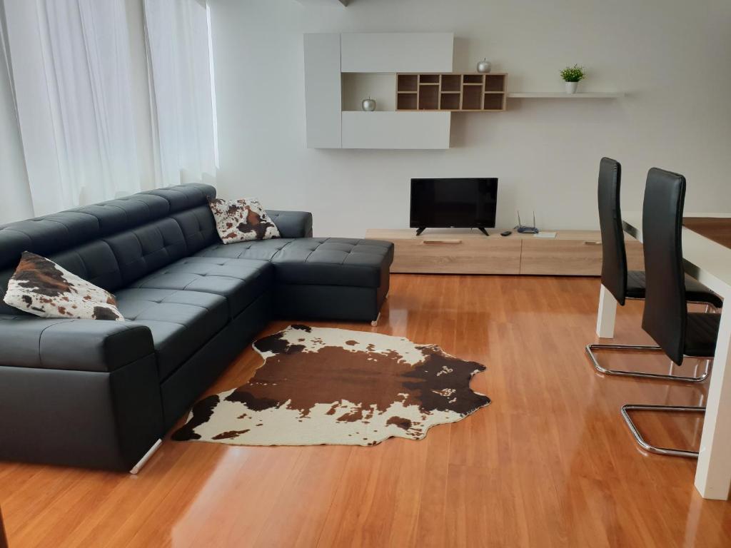 a living room with a black couch and a tv at Funchal Paradise in Funchal