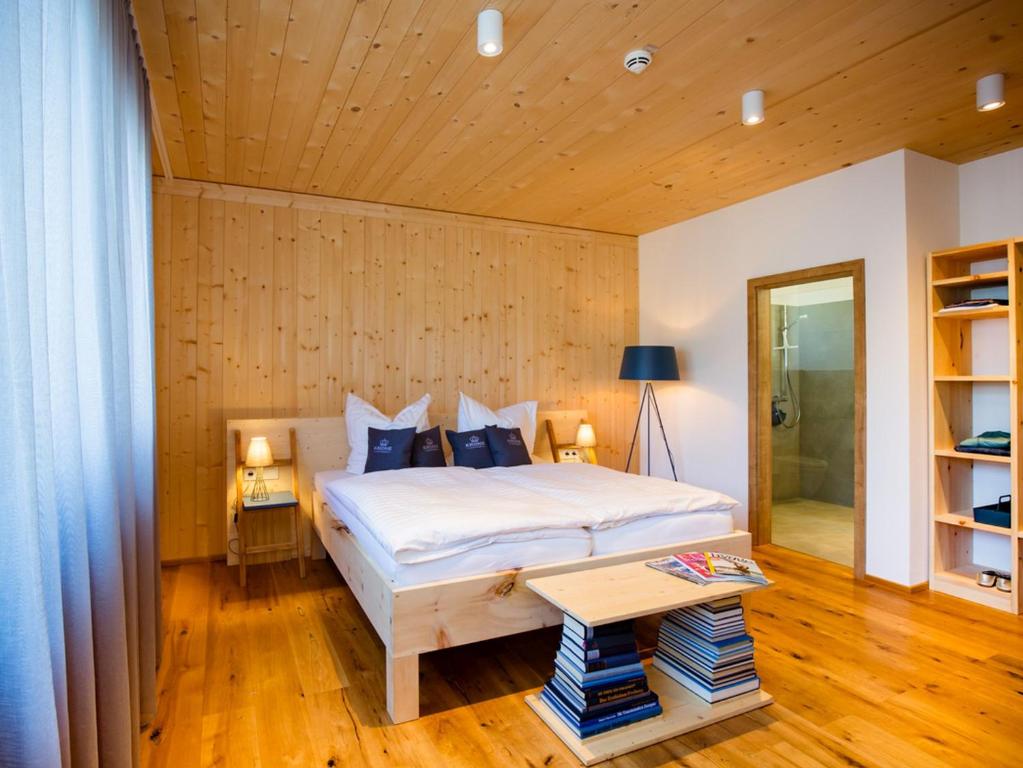 1 dormitorio con 1 cama y pared de madera en Krone Lautlingen en Albstadt