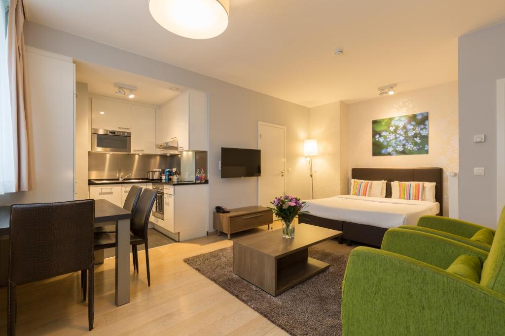 ブリュッセルにあるトーン レジデンス フローレンス アパートホテルのベッドとリビングルームが備わるホテルルームです。