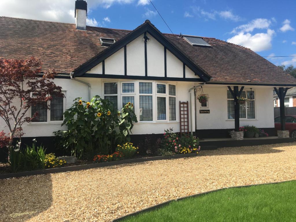 a white house with a gravel driveway at Spurwing Guest House in Wareham