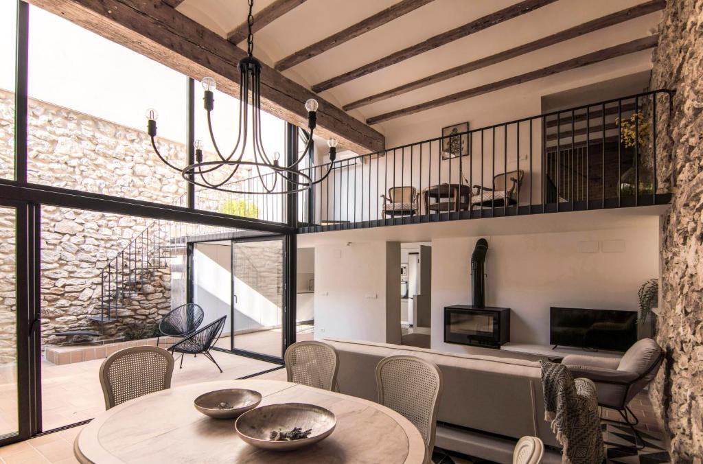 Habitación con mesa, sillas y chimenea. en La Casa del Canal en Roquetas