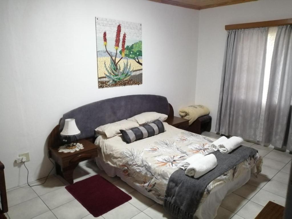 una camera da letto con un letto con cuscini sopra di Hippo Farm Apartment a Gobabis