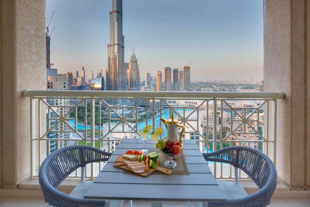 a table on a balcony with a view of a city at Durrani Homes - Designer 2BR Apt with stunning Burj khalifa and Fountain View in Dubai