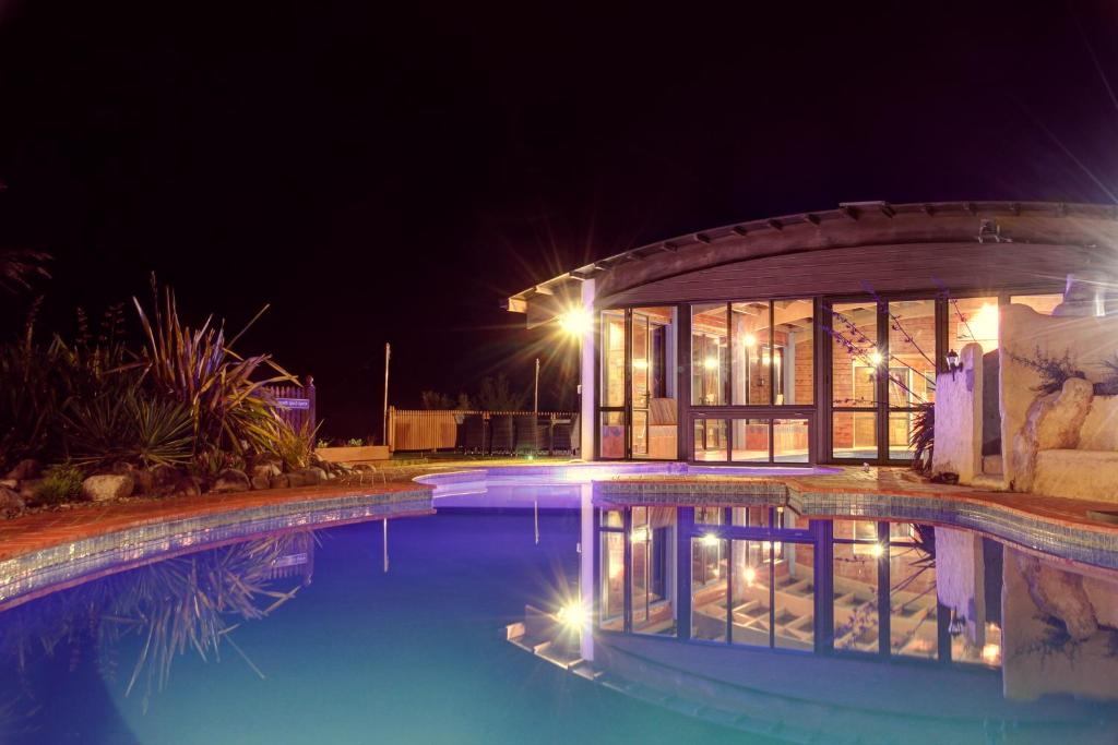 a house with a swimming pool at night at Kimi Ora Eco Resort in Kaiteriteri