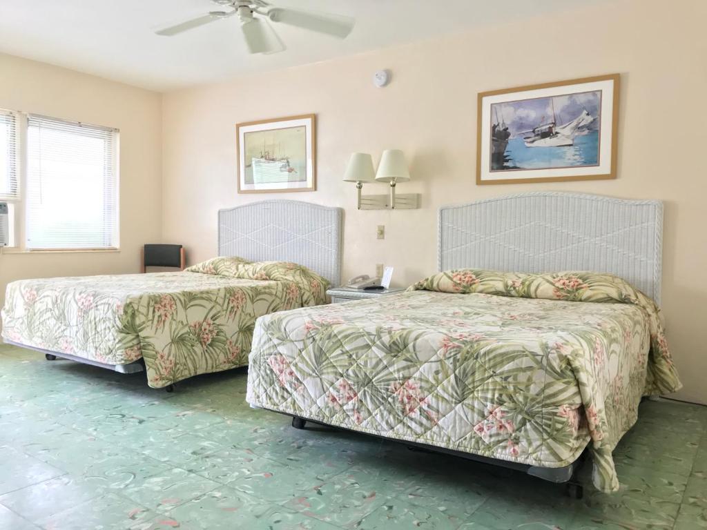 1 Schlafzimmer mit 2 Betten und einem Tisch mit einem Ventilator in der Unterkunft El Patio Motel in Key West