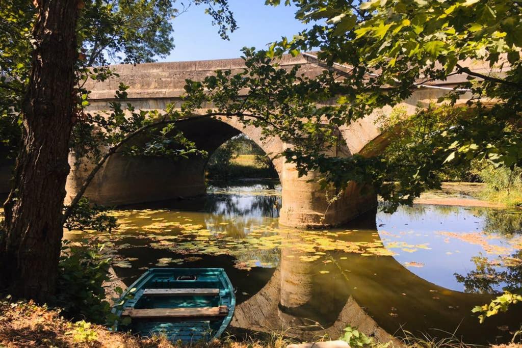 a boat in a river under a bridge at Au bord de l eau in Pesmes