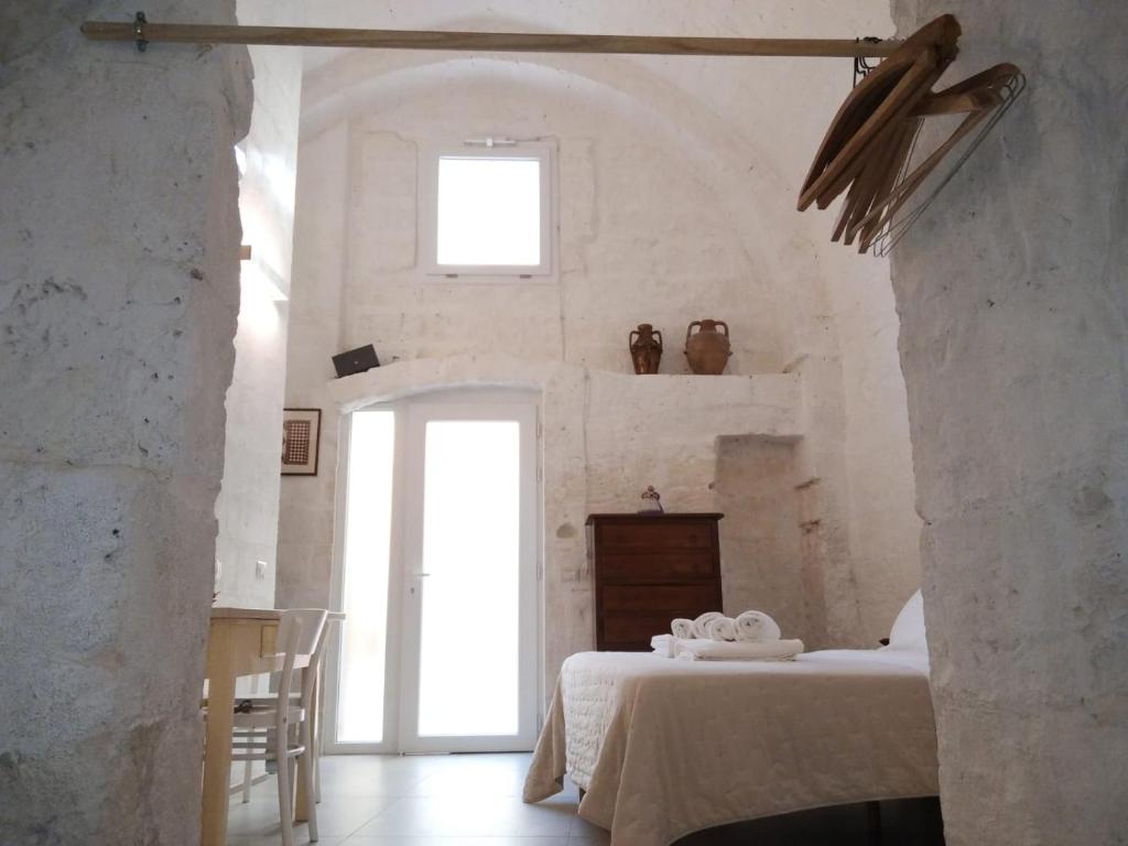 a bedroom with a bed in a white room at Palazzo Enselmi in Matera