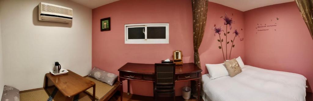 a bedroom with a bed and a desk and a phone at Share B&amp;B in Puli
