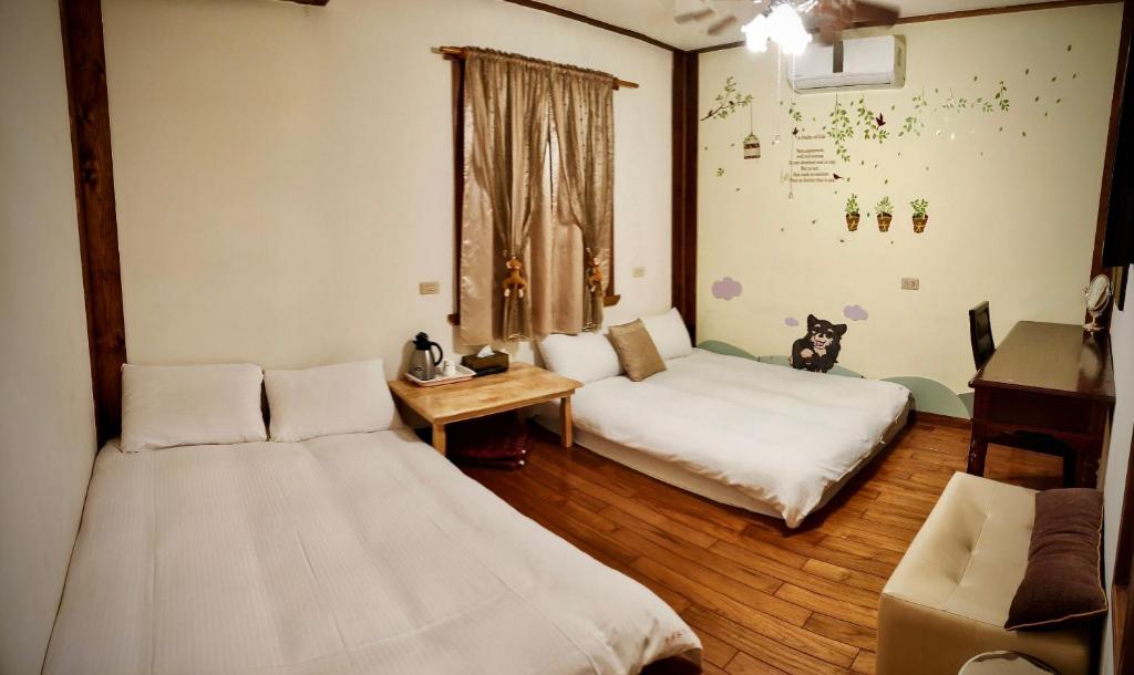 a room with two beds and a table and a couch at Share B&amp;B in Puli