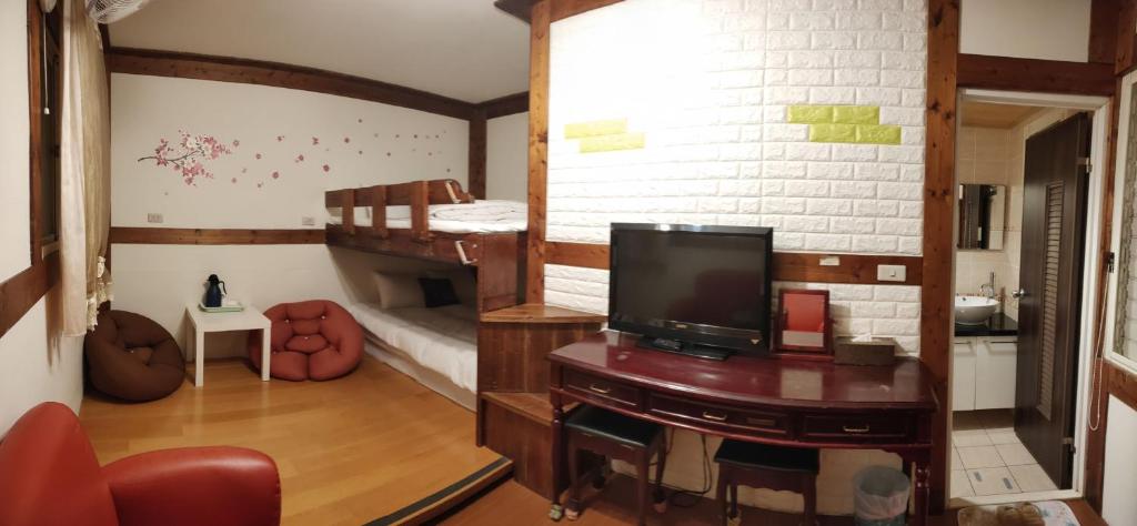 a room with two bunk beds and a flat screen tv at Share B&amp;B in Puli