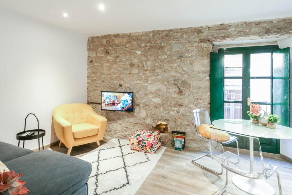 ein Wohnzimmer mit einem Sofa und einem Tisch in der Unterkunft Tresor Boutique Apartment in Girona