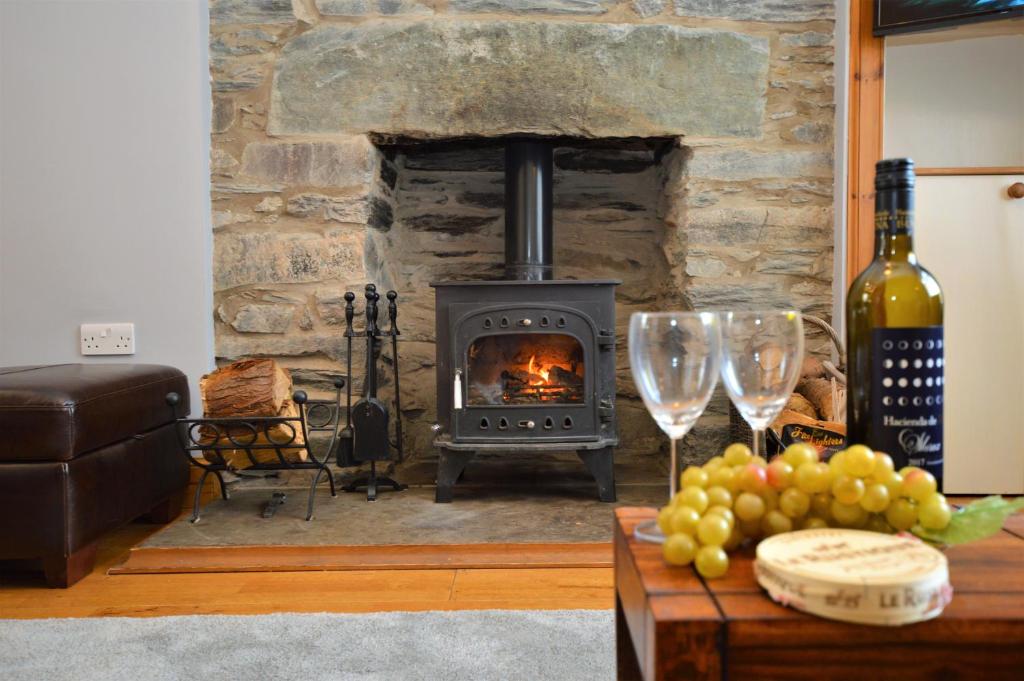 a living room with a fireplace and a table with wine glasses at Freeland Cottage in Dunoon