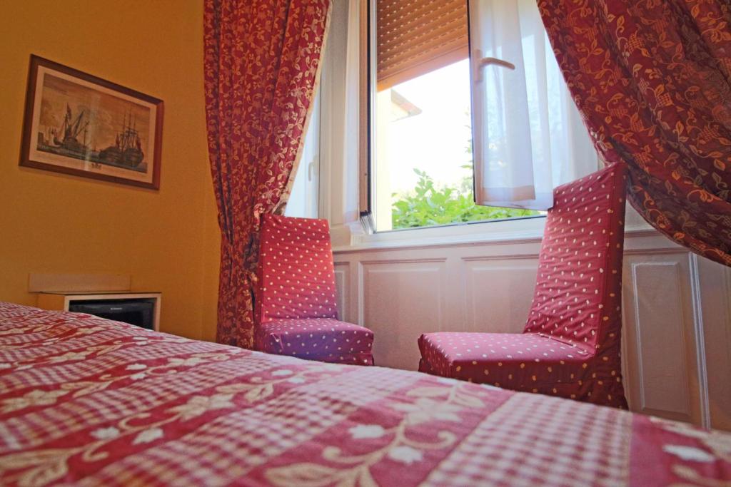 a bedroom with two chairs and a bed and a window at Il Giardino Di Albaro in Genoa