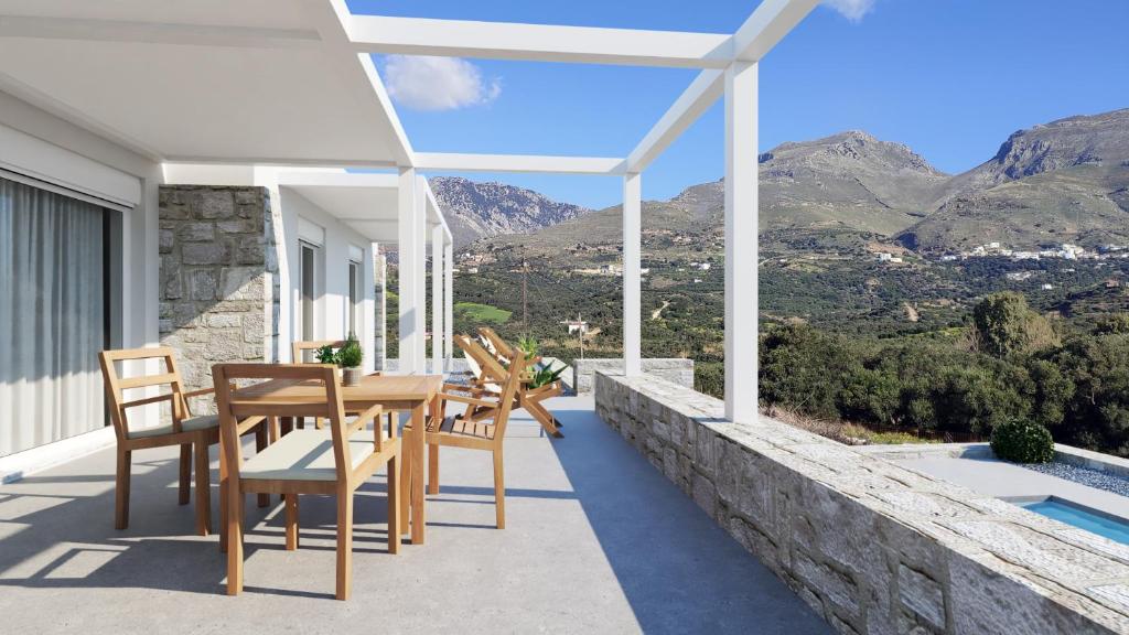 a patio with a table and chairs on a house at Velagio Villas Plakias in Damnoni