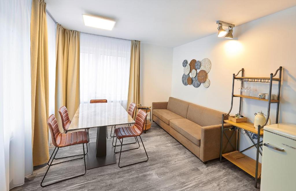 sala de estar con sofá, mesa y sillas en Excellentas Apartments Hannover, en Hannover