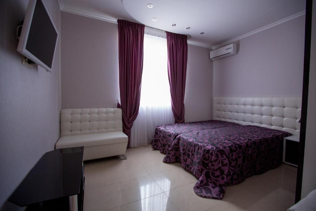 1 dormitorio con 1 cama y una ventana con cortinas rojas en Apartments Near The Airport, en Adler