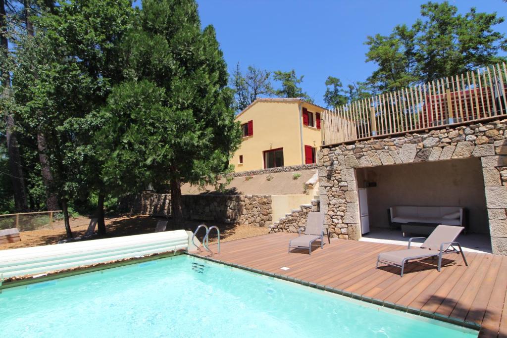 - une piscine avec une terrasse et une maison dans l'établissement Gîte des arts premiers, à Rosières
