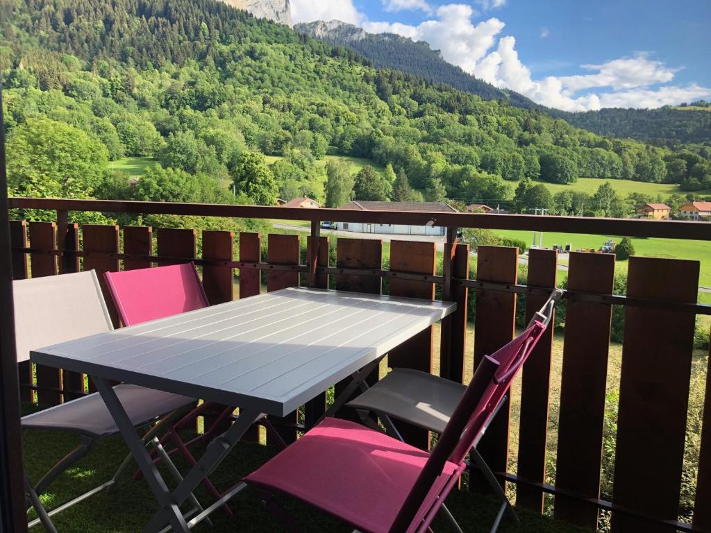 een tafel en stoelen op een balkon met uitzicht op een berg bij Studio entièrement rénové entre lac et montagne in Thollon