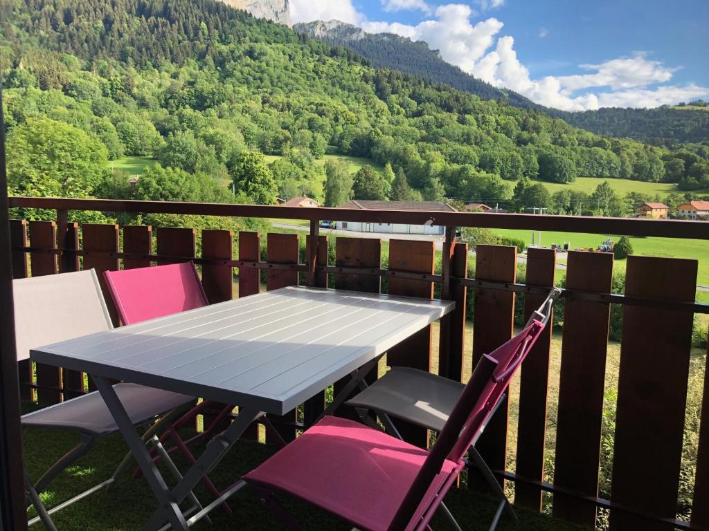 une table et des chaises sur un balcon avec vue sur une montagne dans l'établissement Studio agréable et cosy avec vue sur les Mémises, à Thollon-les-Mémises