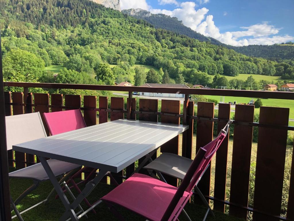 a table and chairs on a balcony with a view of a mountain at Studio entièrement rénové entre lac et montagne in Thollon