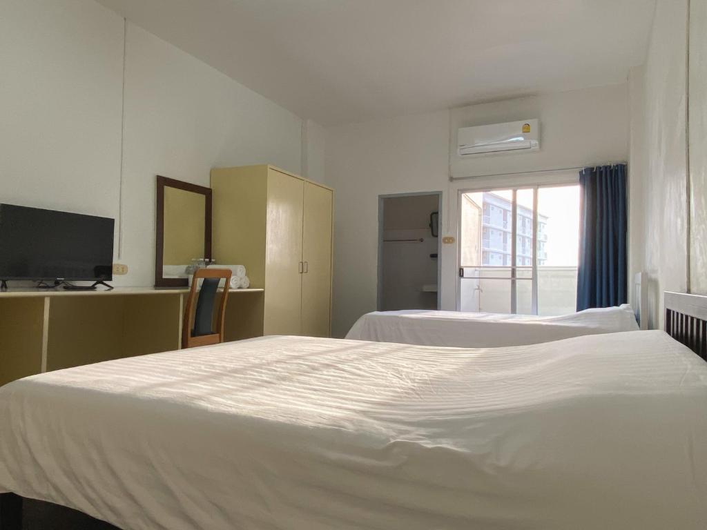 バンセーンにあるMonta Apartmentのベッド2台とテレビが備わるホテルルームです。