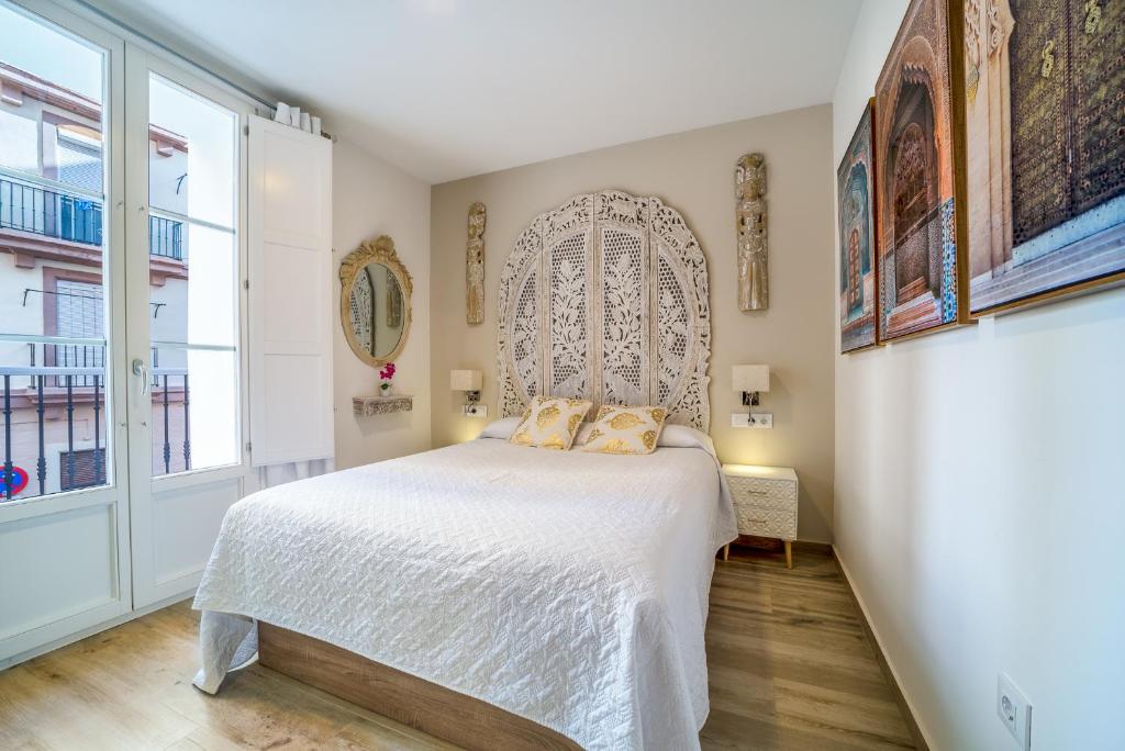 ein Schlafzimmer mit einem Bett und einem großen Fenster in der Unterkunft Suite Capitán 2 in Cádiz