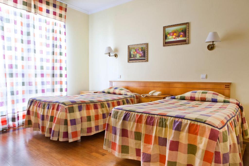 um quarto de hotel com duas camas num quarto em Residencial Colombo em Funchal