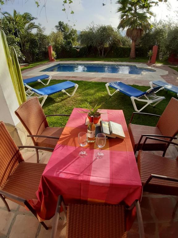 una mesa con copas de vino junto a una piscina en Casa del Lavadero en Montecorto