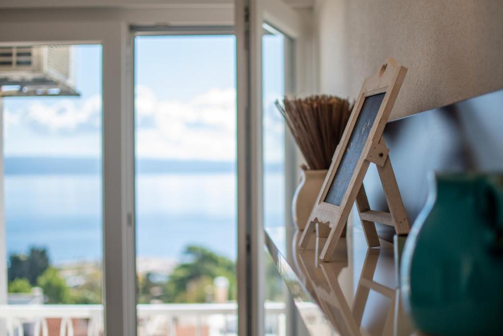 ein Gemälde auf einem Stand neben einem Fenster in der Unterkunft Trstenik Beach Apartment in Split