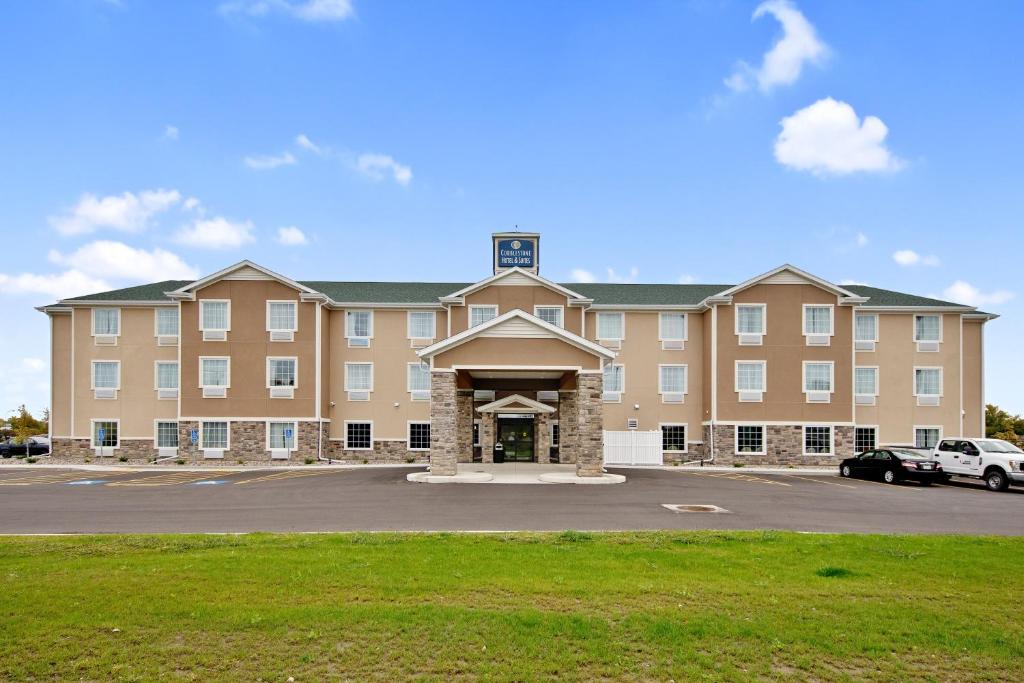 a large building with a parking lot in front of it at Cobblestone Hotel & Suites - Austin in Austin